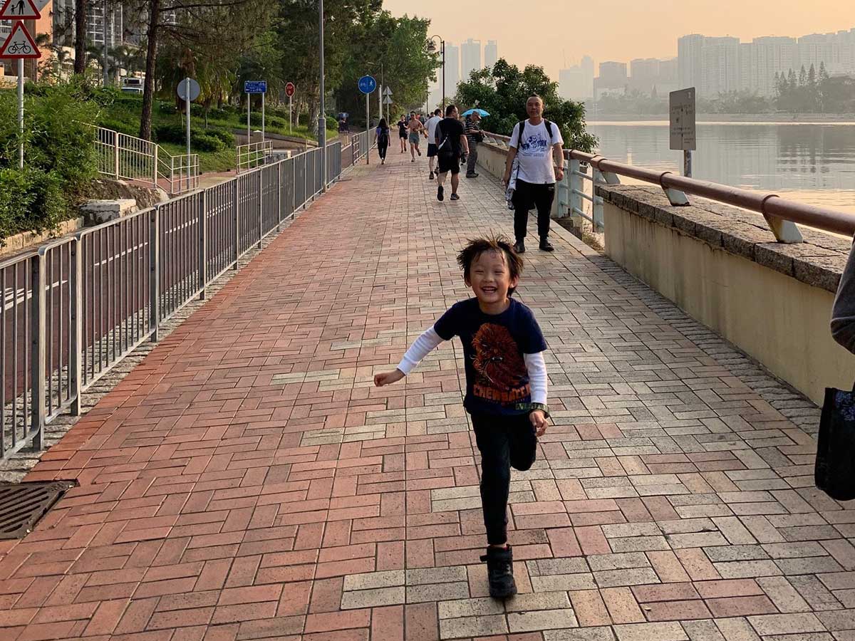 Boy running by the river in Hong Kong