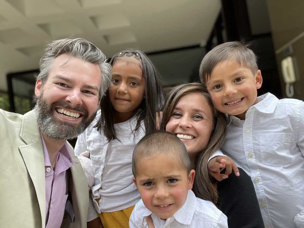 Adoptive parents and three siblings adopted from Colombia smiling