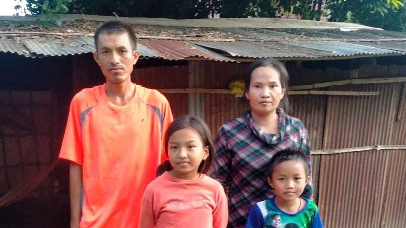 family standing in front of house