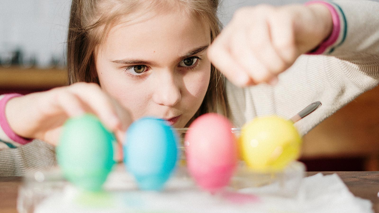 little girl dyeing Easter eggs