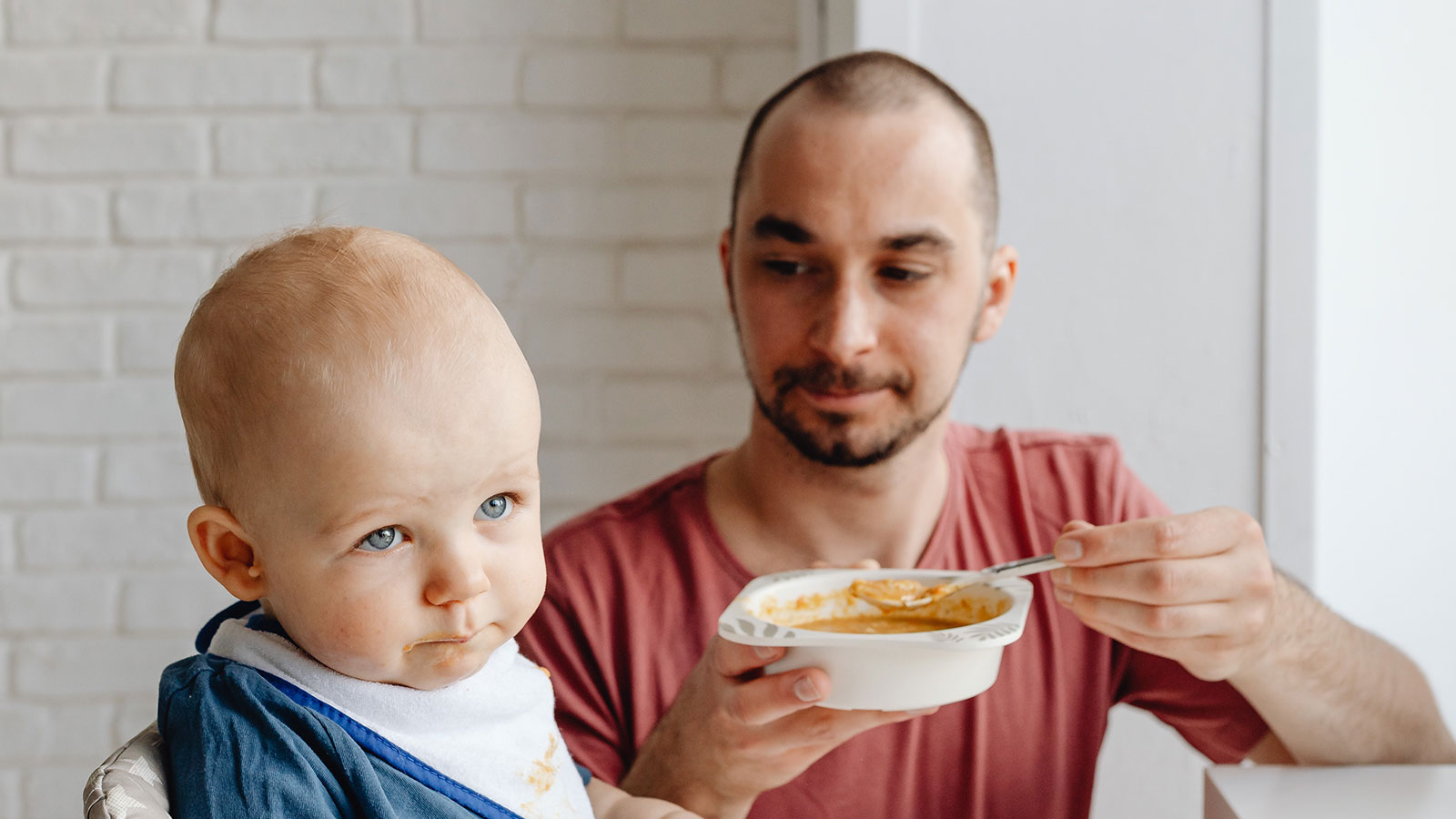 father trying to feed baby