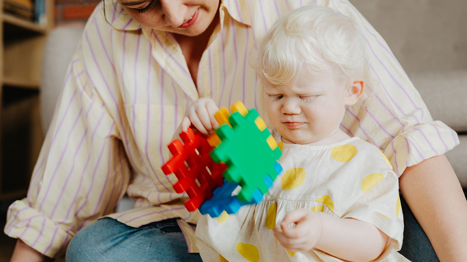 child with albinism holding waffle block toy