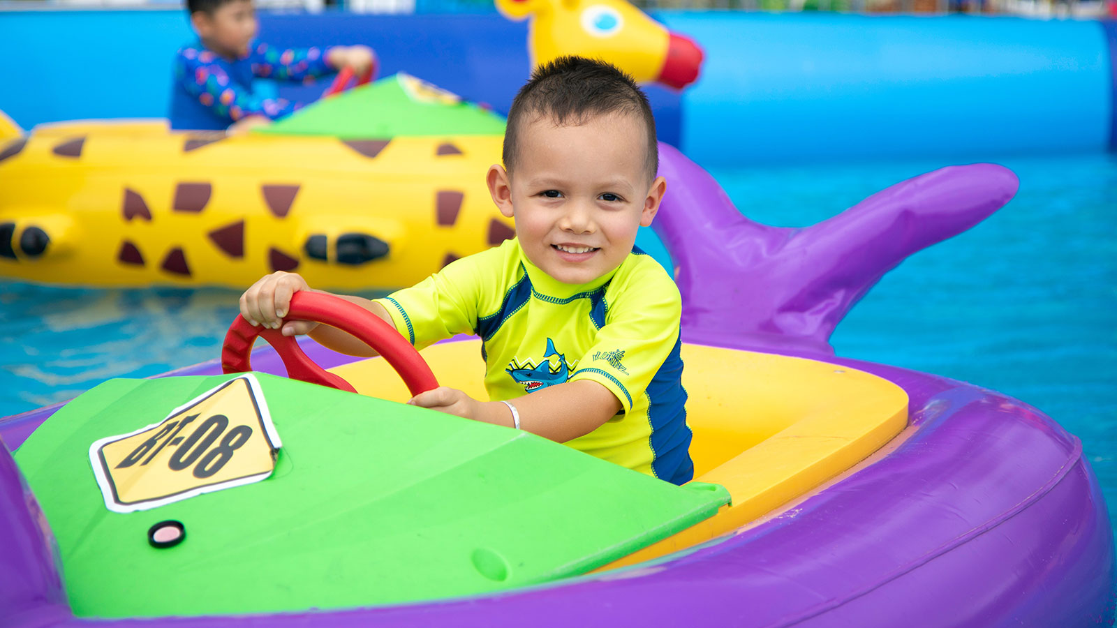 child playing in water bumper car in pool