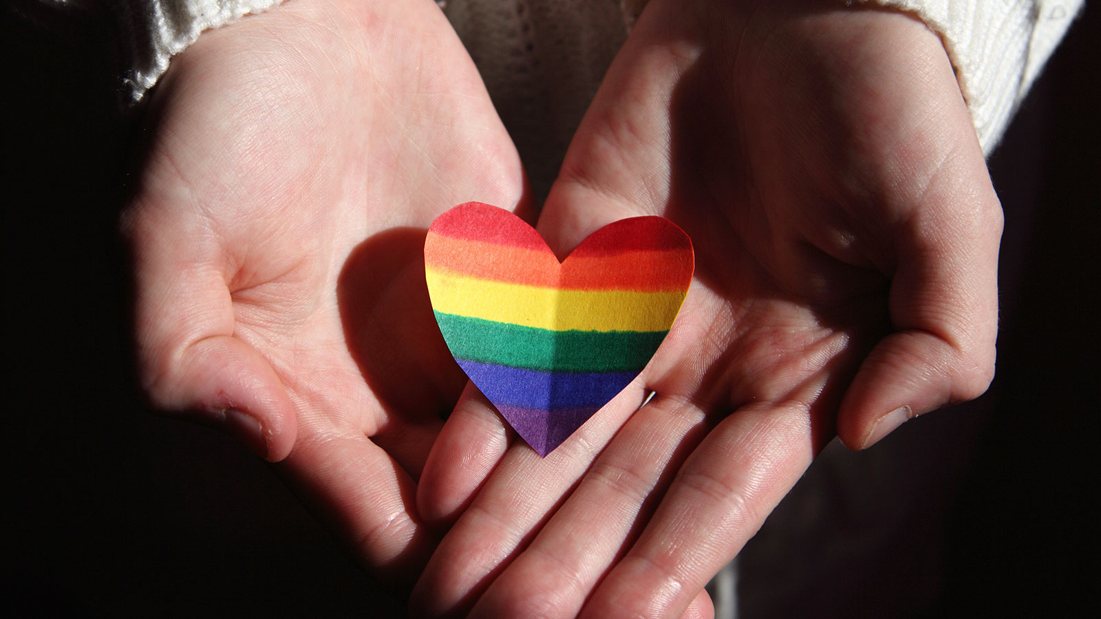 hands holding heart with rainbow colors, gender identity