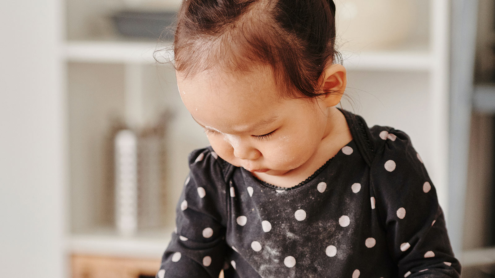 baby girl frowning and looking down