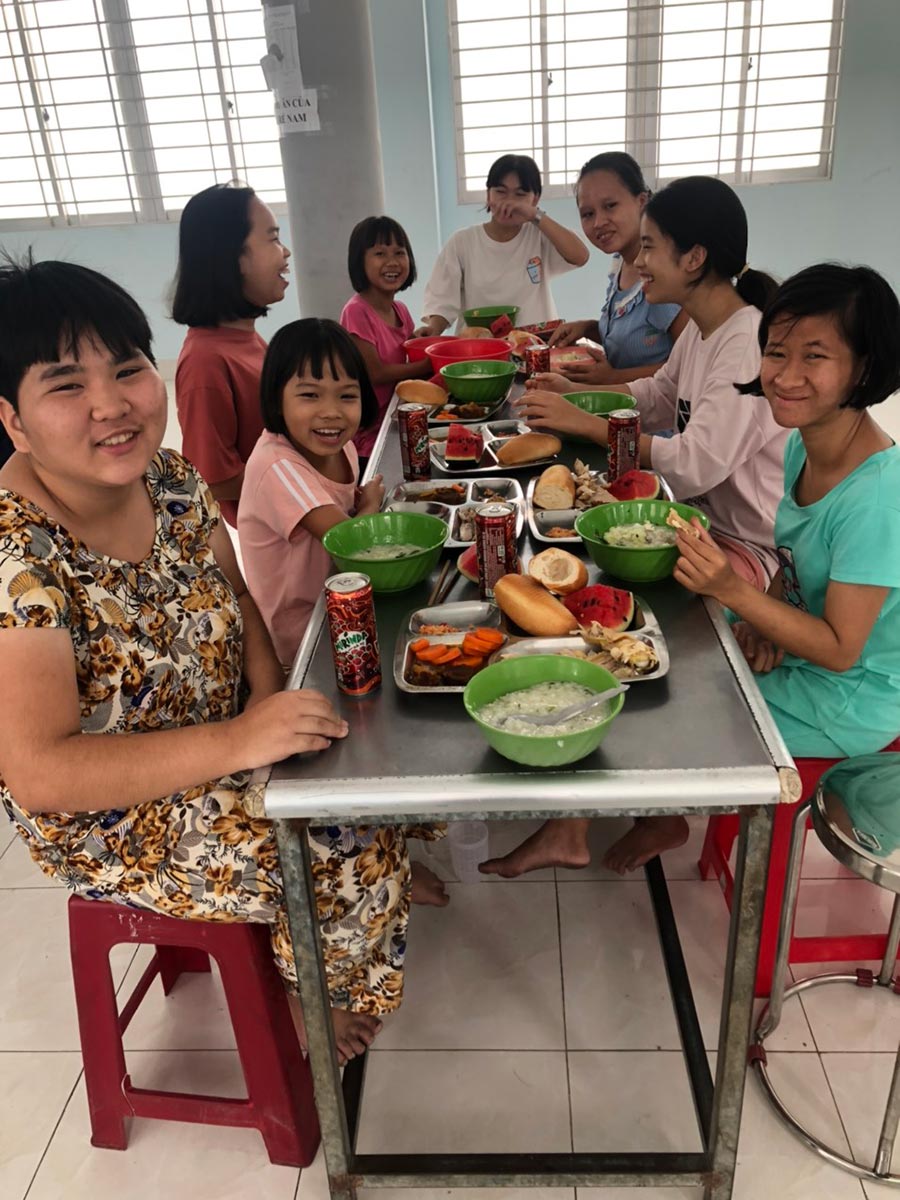 group of smiling girls eating at a table