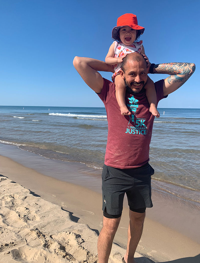 smiling dad holding daughter on his shoulders