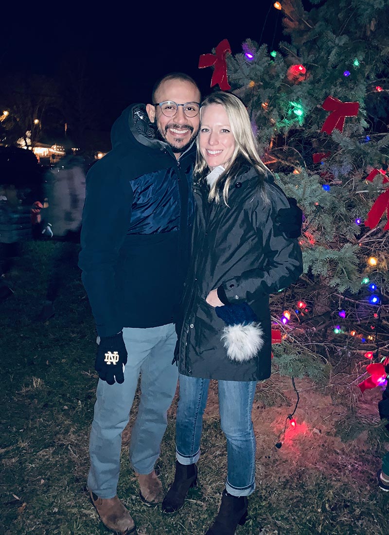 smiling couple in front of christmas tree