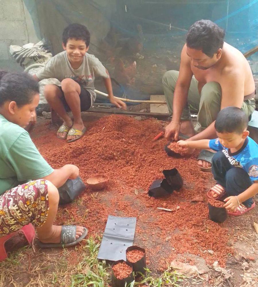 family puts garden mulch into bags