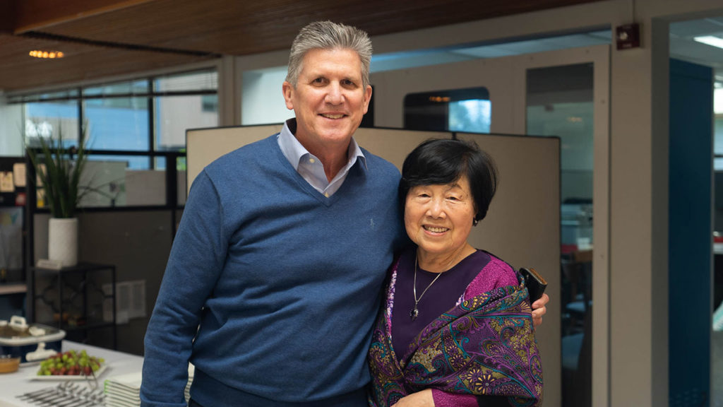 holt ceo phil littleton with arm around nancy kim recipient of harry holt award