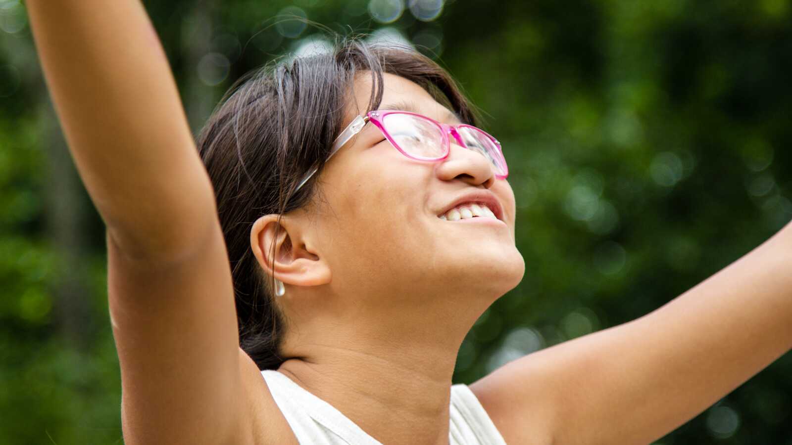 adoptee with pink glasses cheering