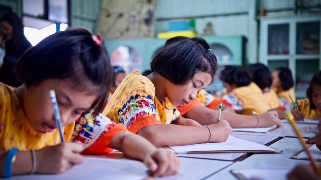 children writing in notebooks