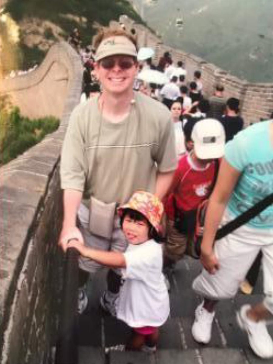 adoptive father with adopted daughter at great wall of china