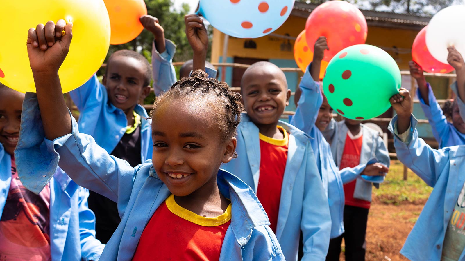 children laughing and playing with colorful balloons