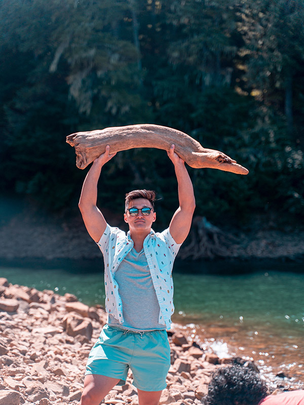 trent jones camp counselor holding up piece of driftwood