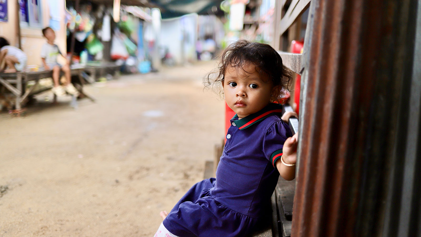 little girl in cambodia sitting on a step