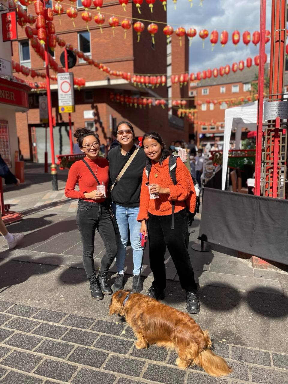 three adoptees smiling for a group photo with dog