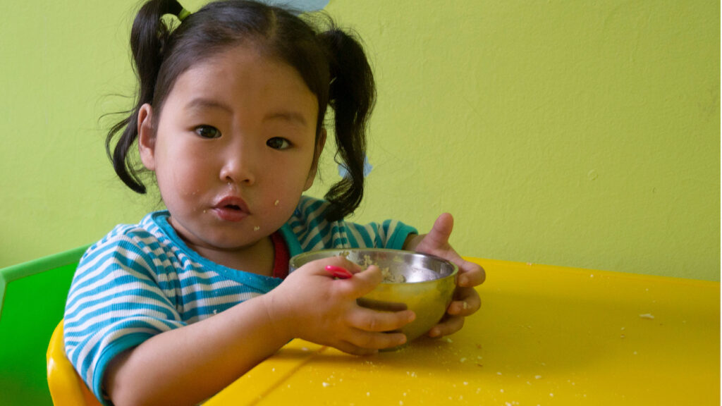 Little girl in Mongolia eating
