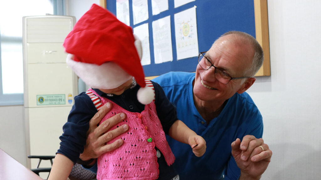 donor and child with santa hat on 2016 korea gift team tour