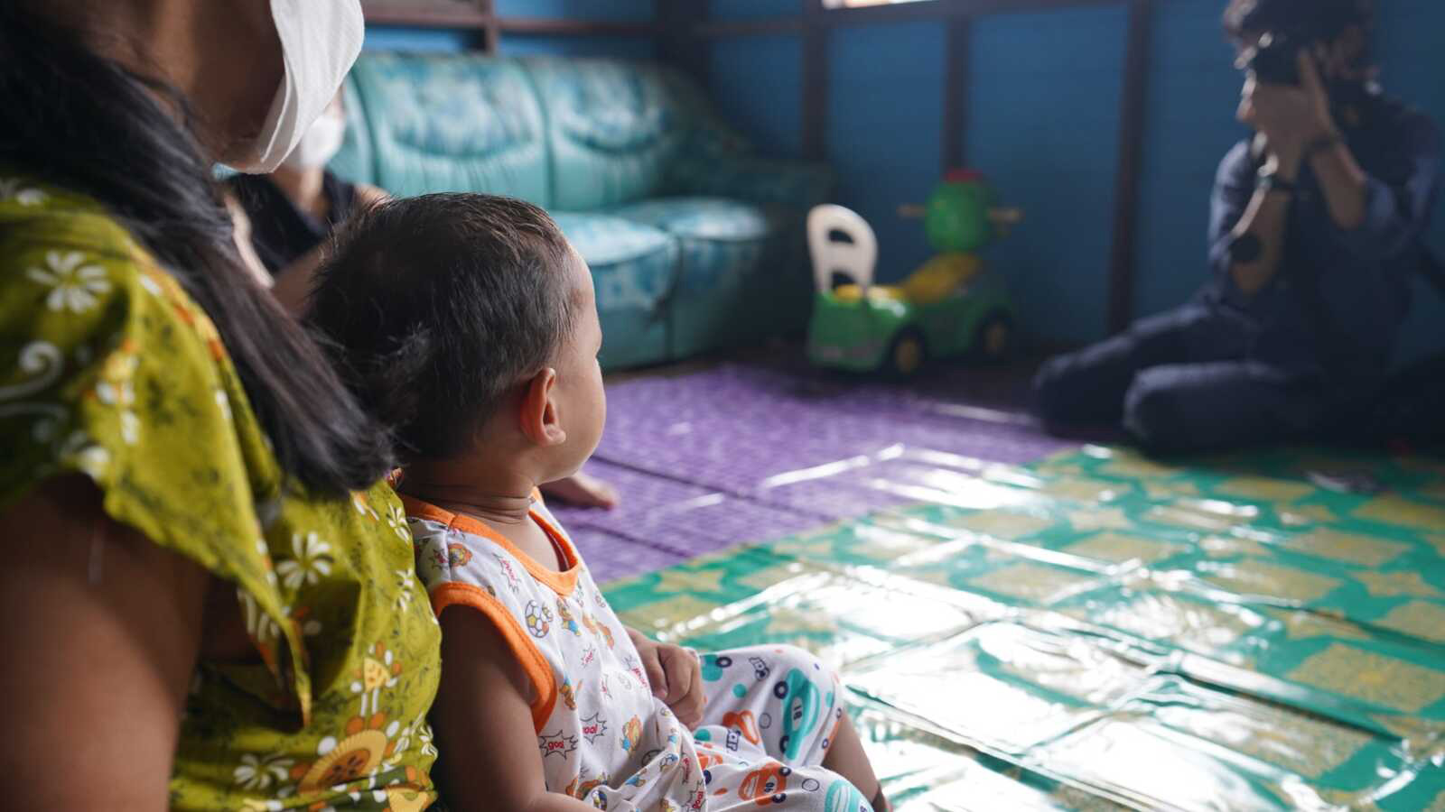 A boy in foster care in Thailand in his foster mom's lap