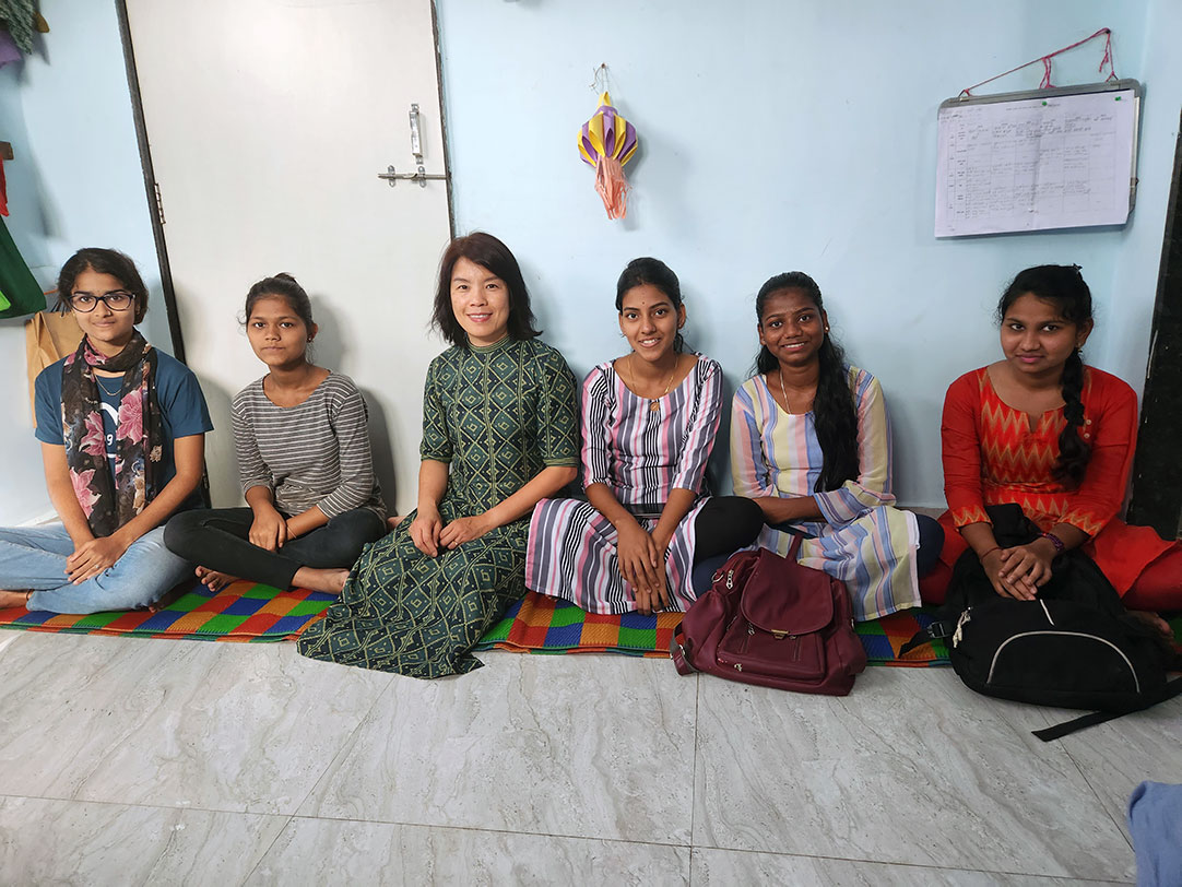 Thoa sits with a group of girls in India