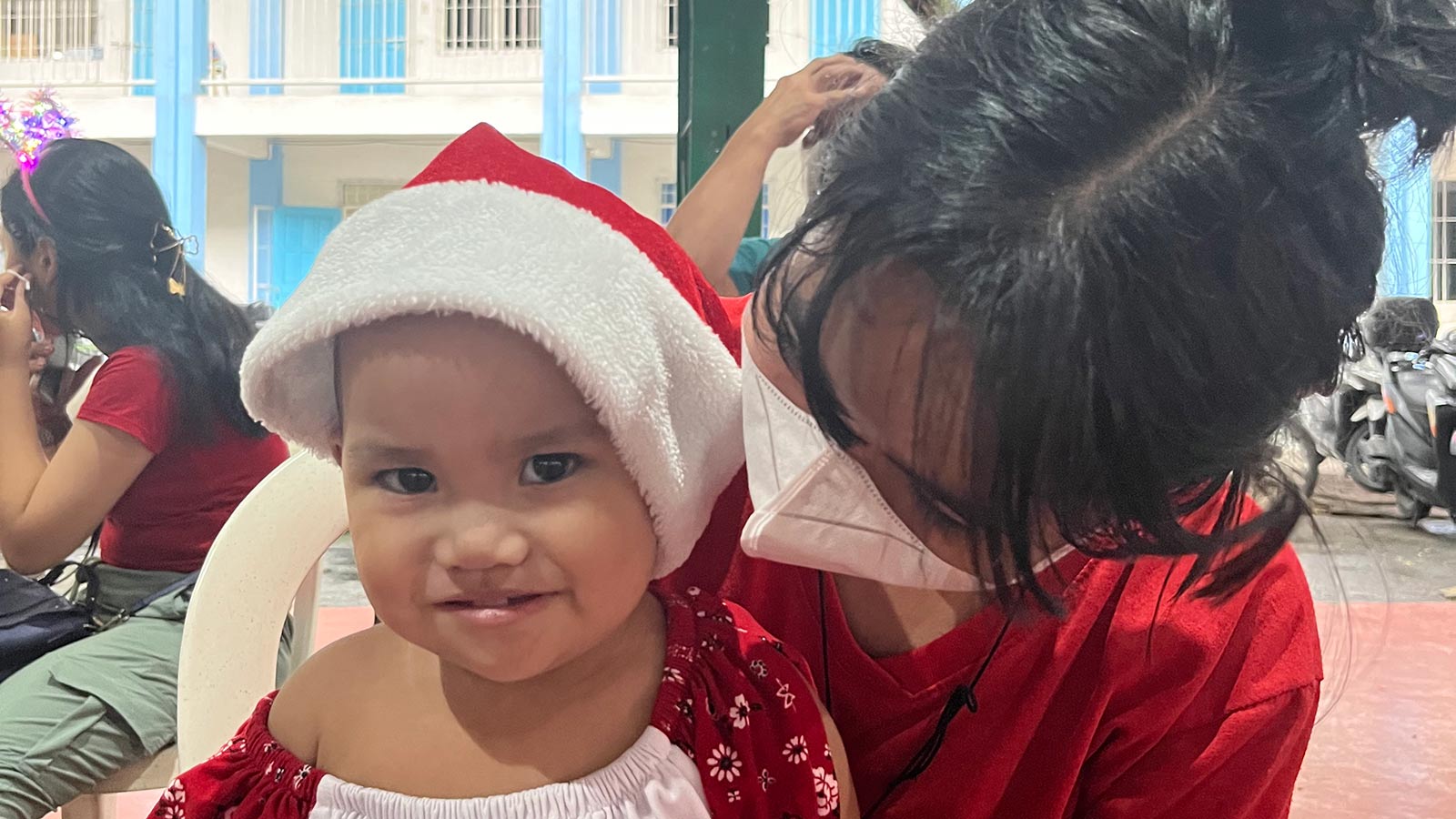 A child and her mom at a Christmas party in the Philippines