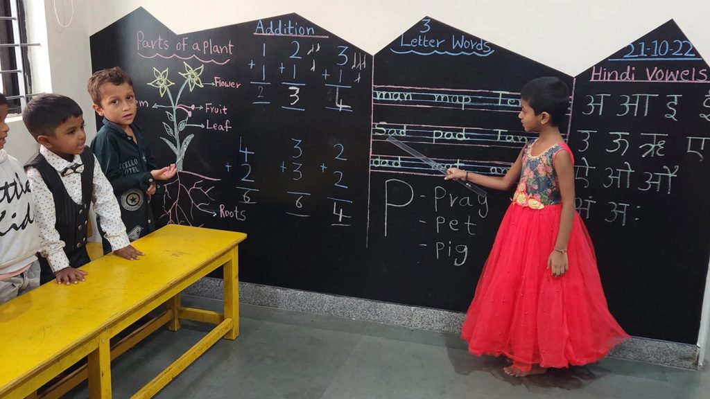 A child at a blackboard at the daycare for migrant children in India