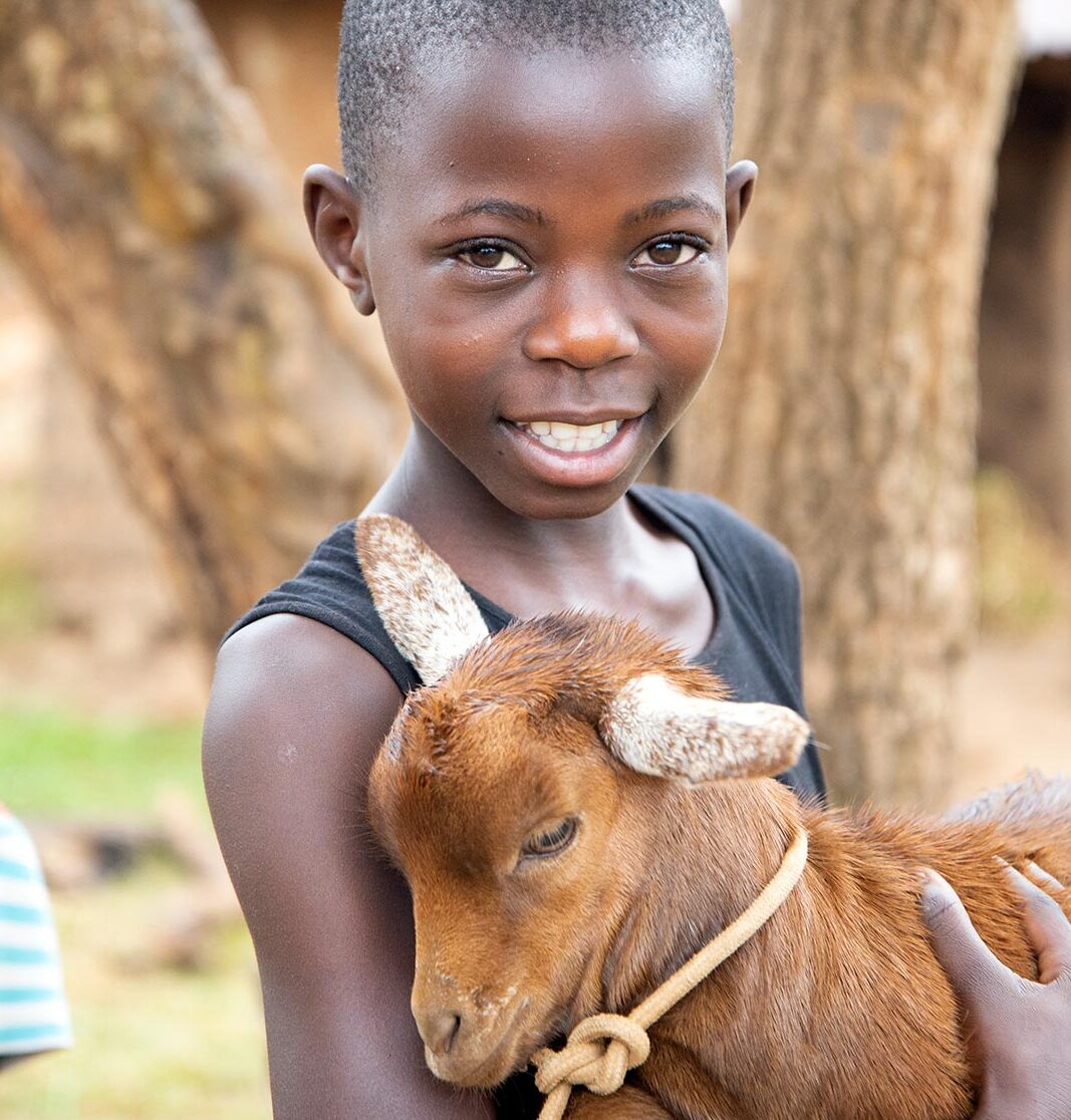 A girl in Uganda holds a goat