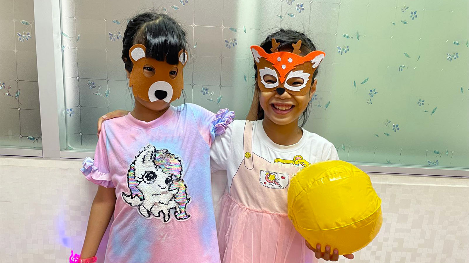Two girls laughing with animal masks