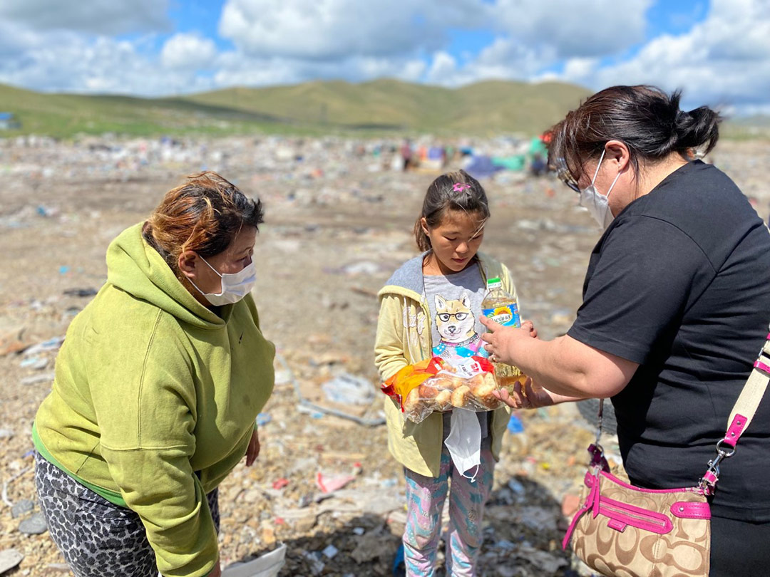 A girl in Mongolia receives food from a Holt social worker