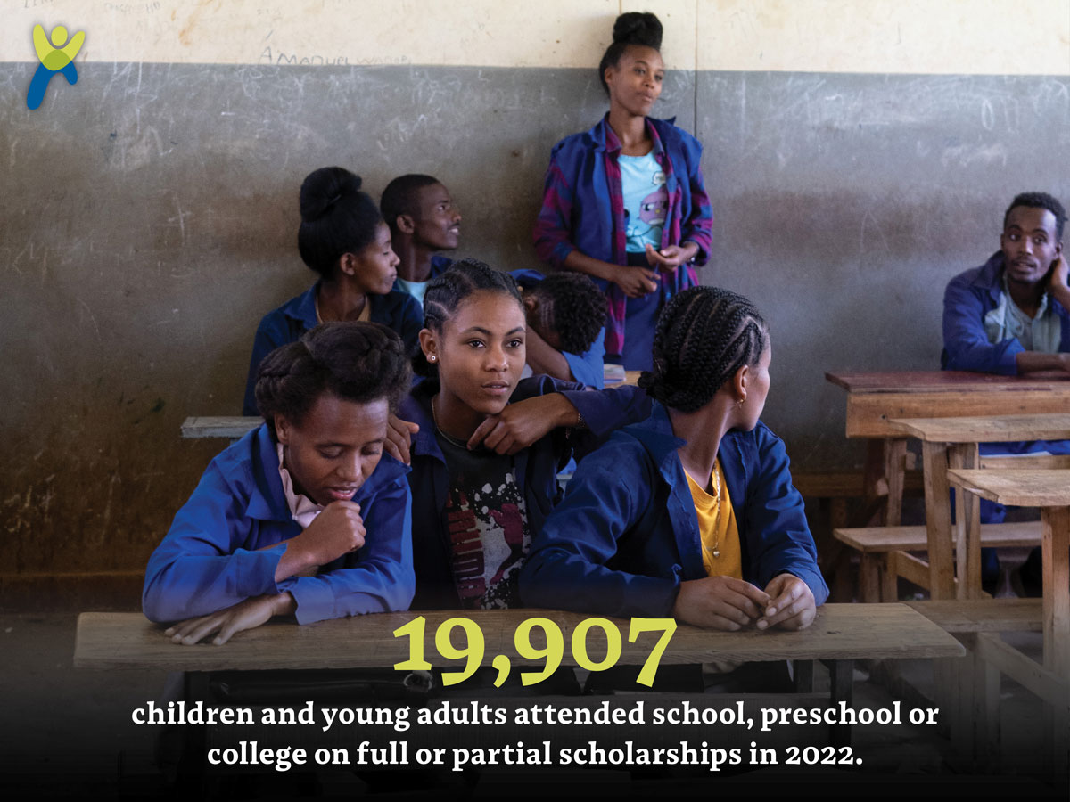 Teenage girls in a classroom in Ethiopia with a global giving in 2022 impact number.