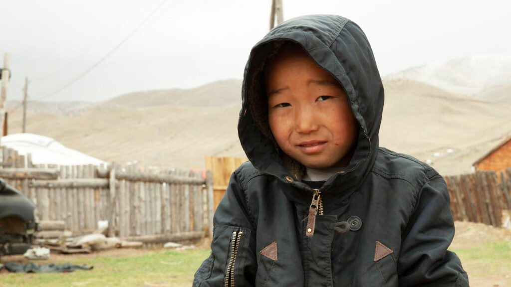 Young boy in Mongolia standing in the cold