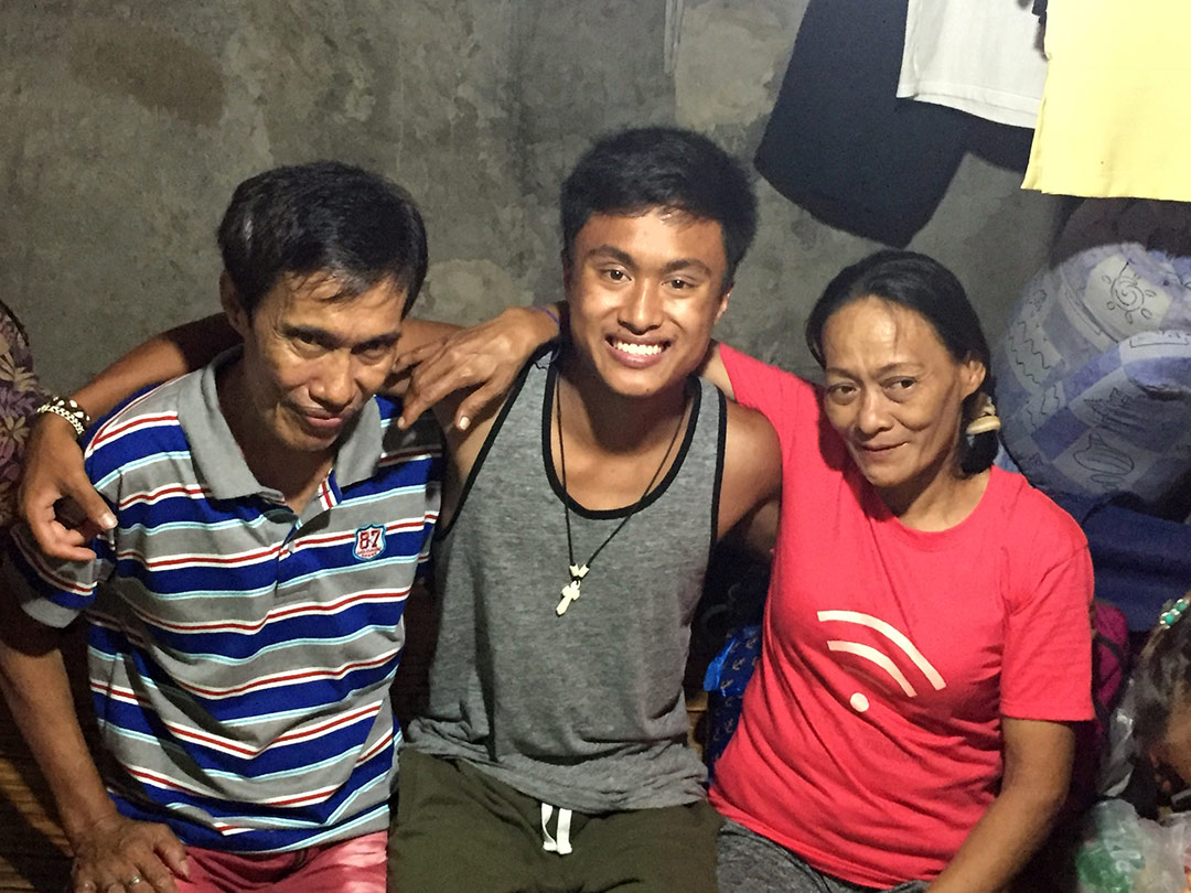 A teenage adoptee poses with his birth dad and birth mom in the Philippines