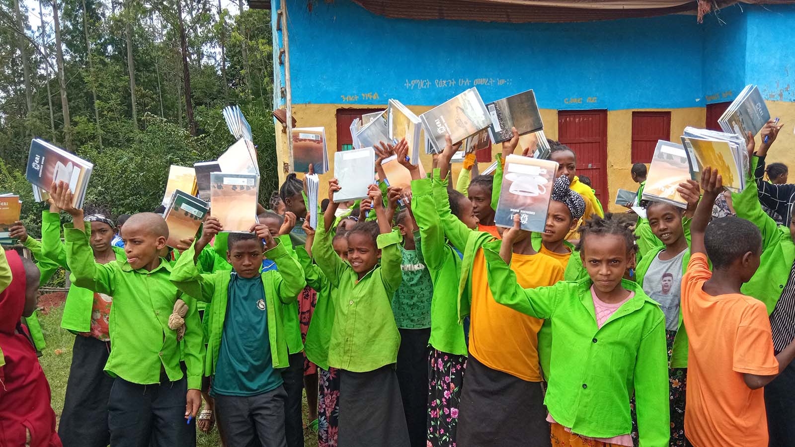 Children at Walana School Ethiopia holding new school supplies