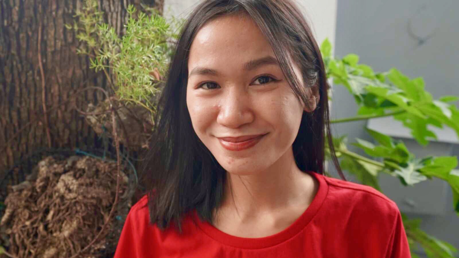 ILEA scholar Isla smiling in a red shirt outside the ILEA house