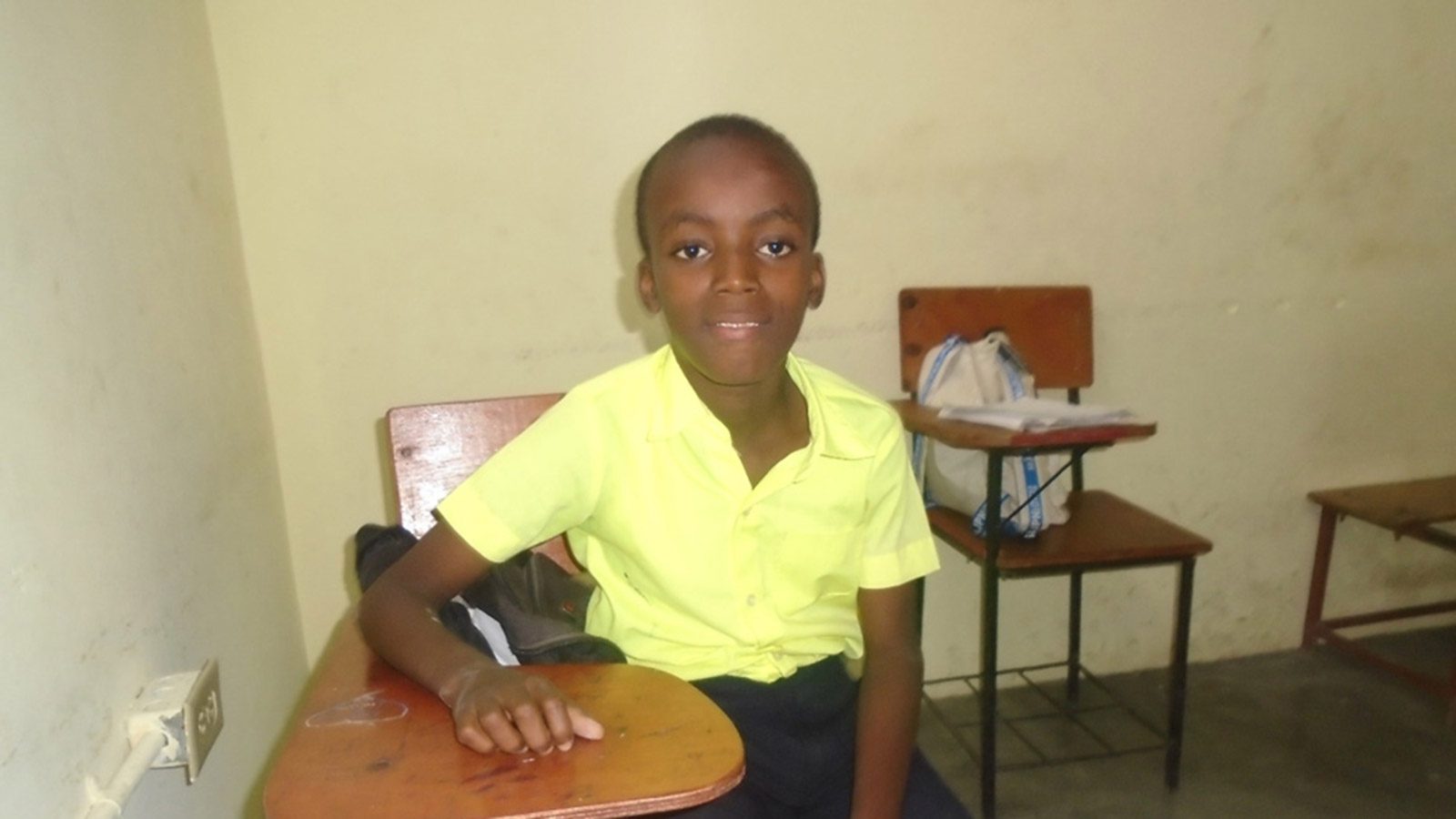 Sponsored child Samuel in a school uniform in a classroom in Haiti