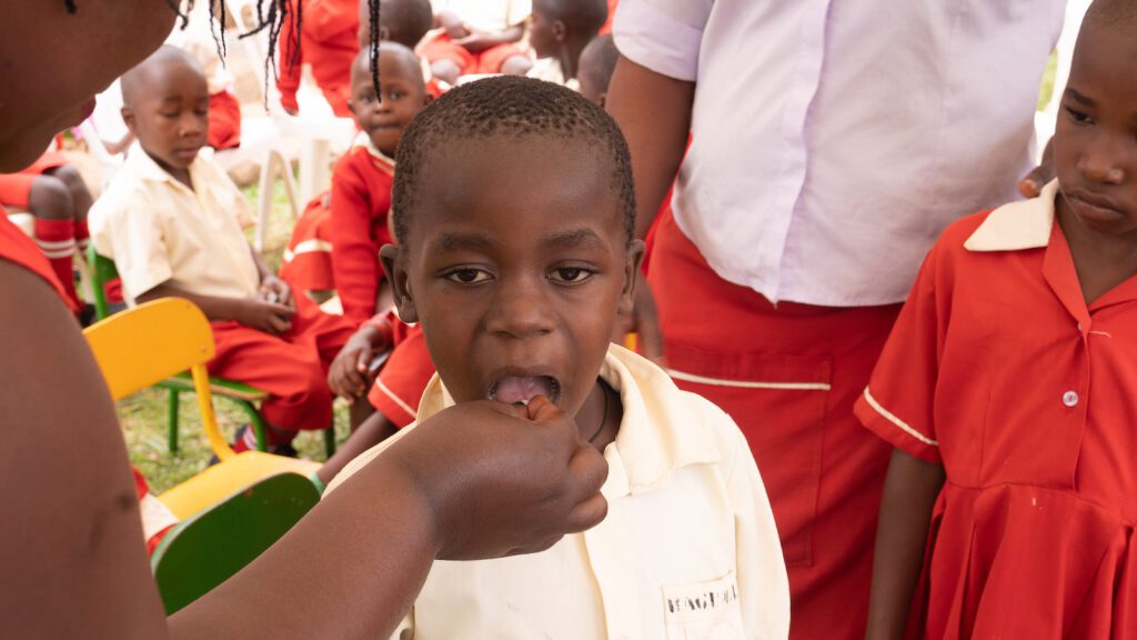 A little boy receiving deworming medication in Uganda