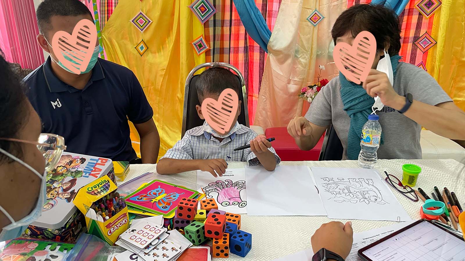 Little boy sits at table playing with toys during assessment