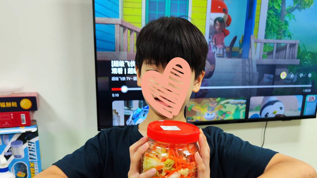 Young boy smiles holding jar of candy