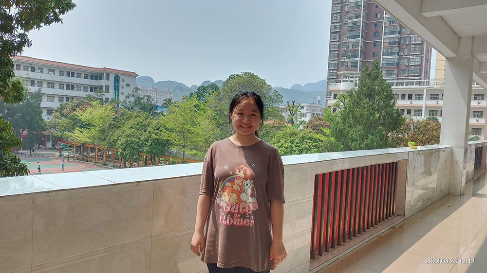 Girl in China stands outside smiling