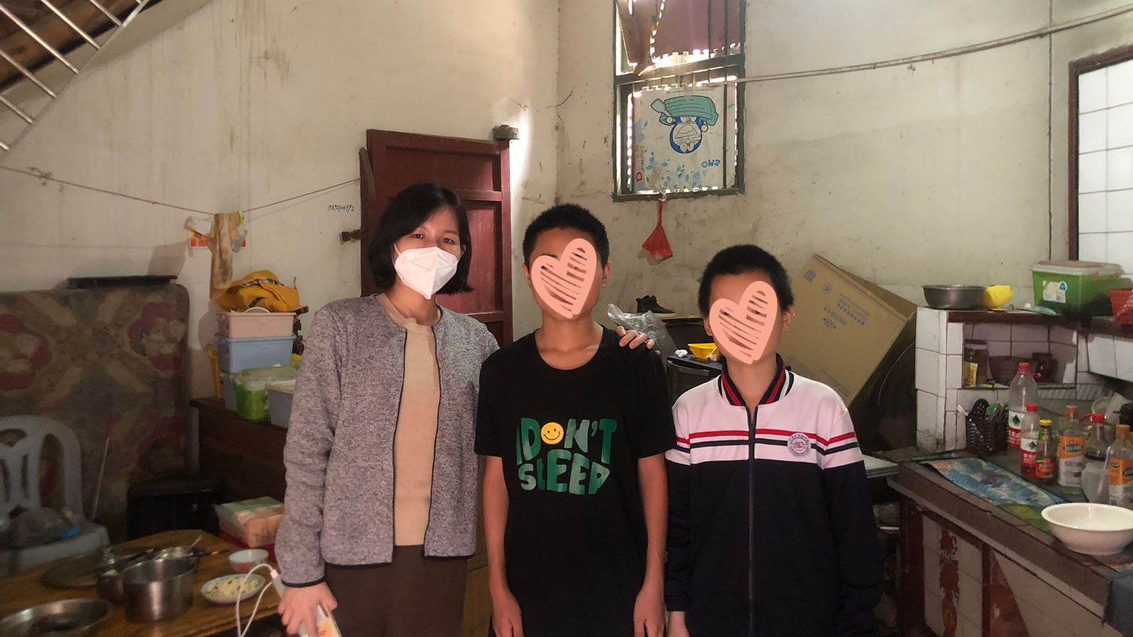 Boys stand in kitchen with social worker