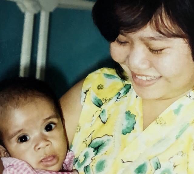 Social worker in yellow blouse holds small baby, Vietnamese adoptee Chad Hassebrook