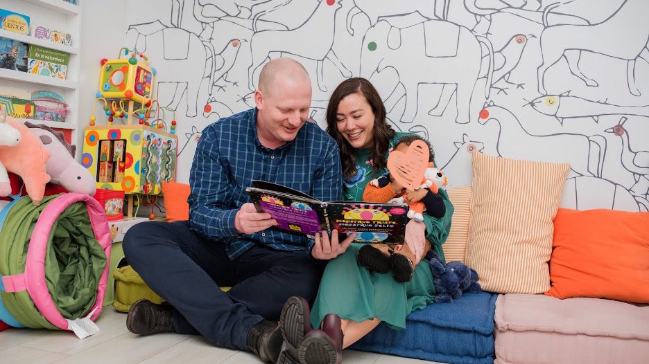 Parents read a book with toddler