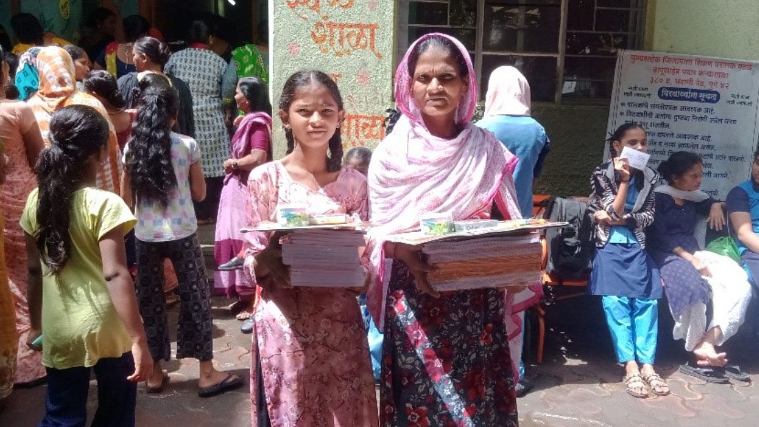 Young girl and older woman hold new books in India