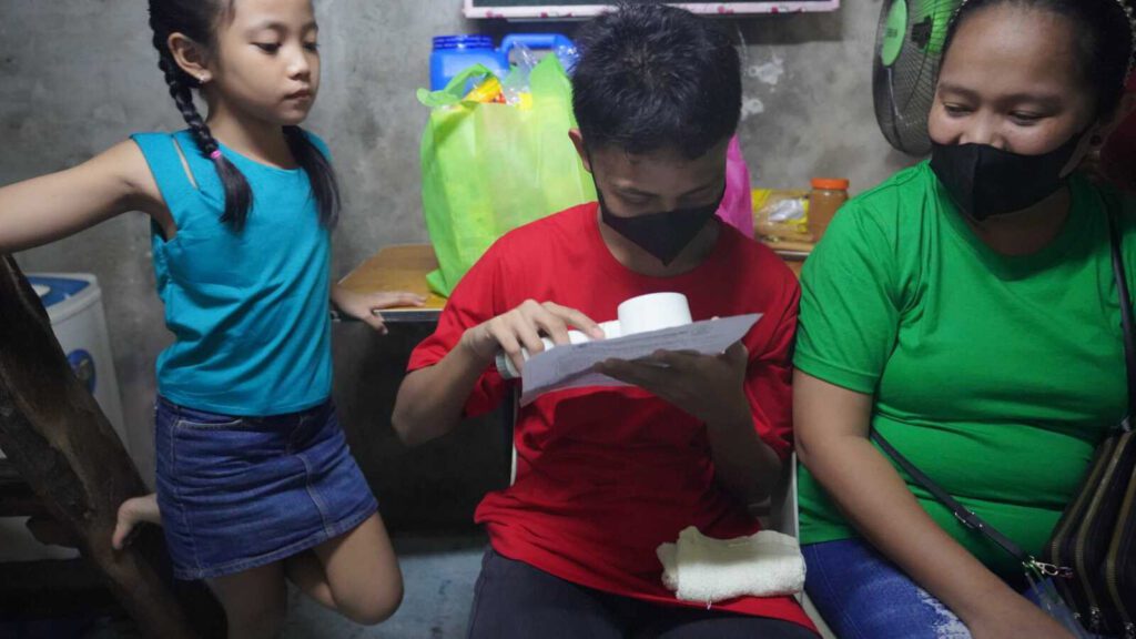 Gabriel, a visually impaired boy in educational sponsorship in the Philippines, shows how he uses a magnifying glass to read.