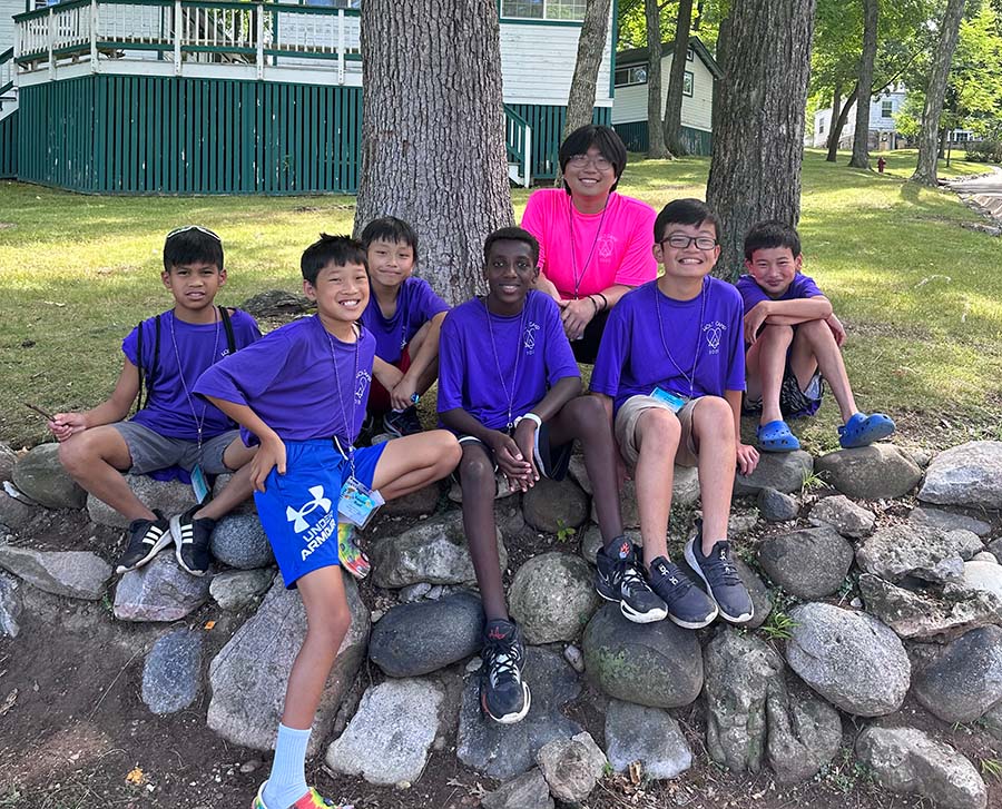 Group of kids sits on rocks smiling