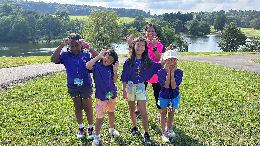 Holt adoptee camp campers and counselor make a silly face
