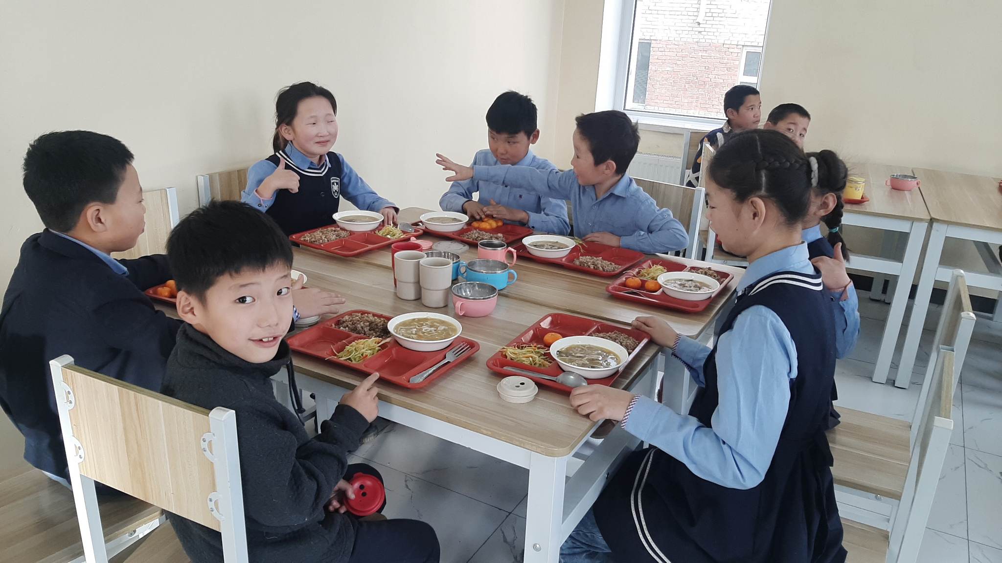 Group of children seated around table enjoy school lunch!