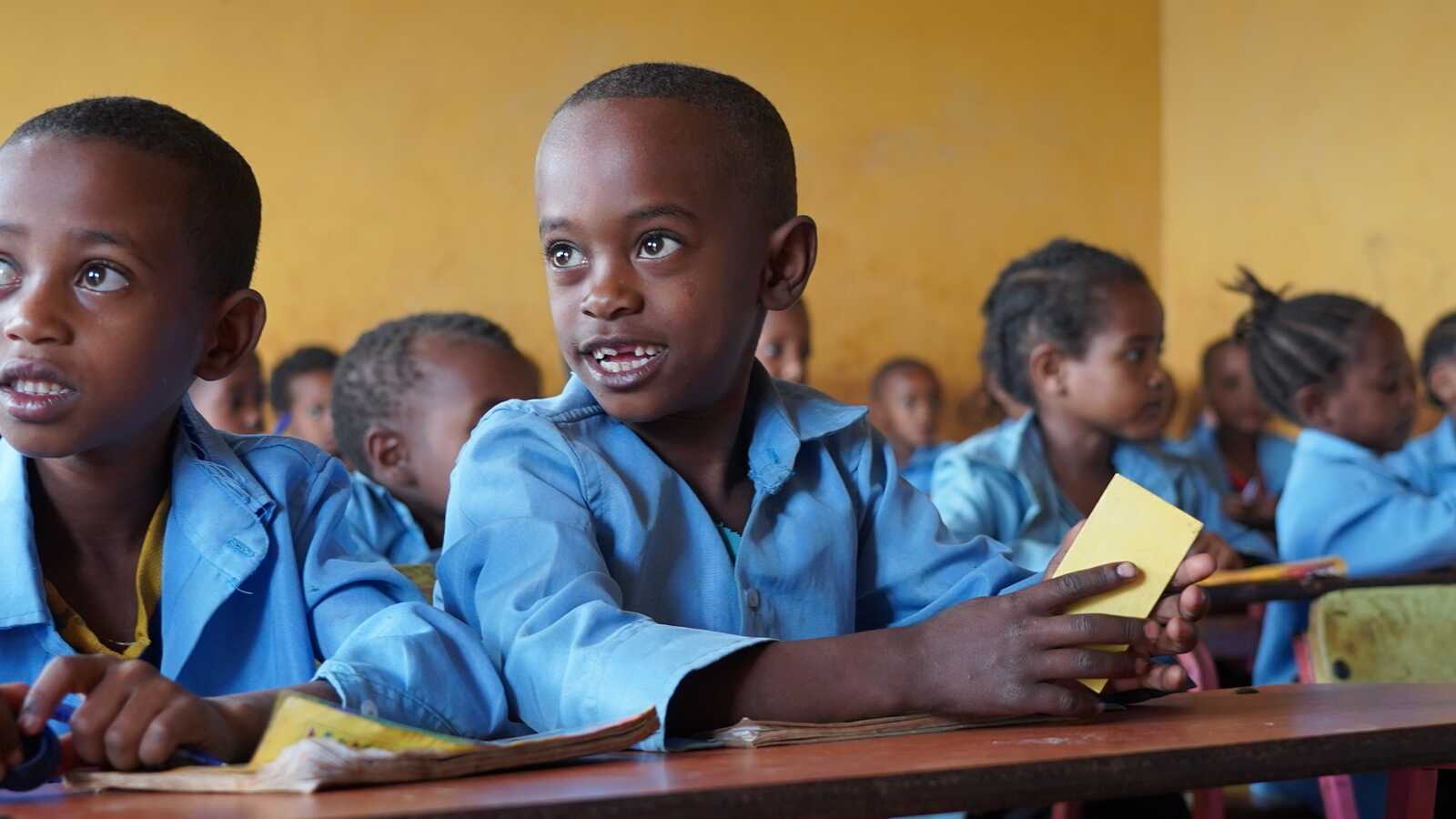 Children in uniforms sit at desks in Wallana classroom in Ethiopia