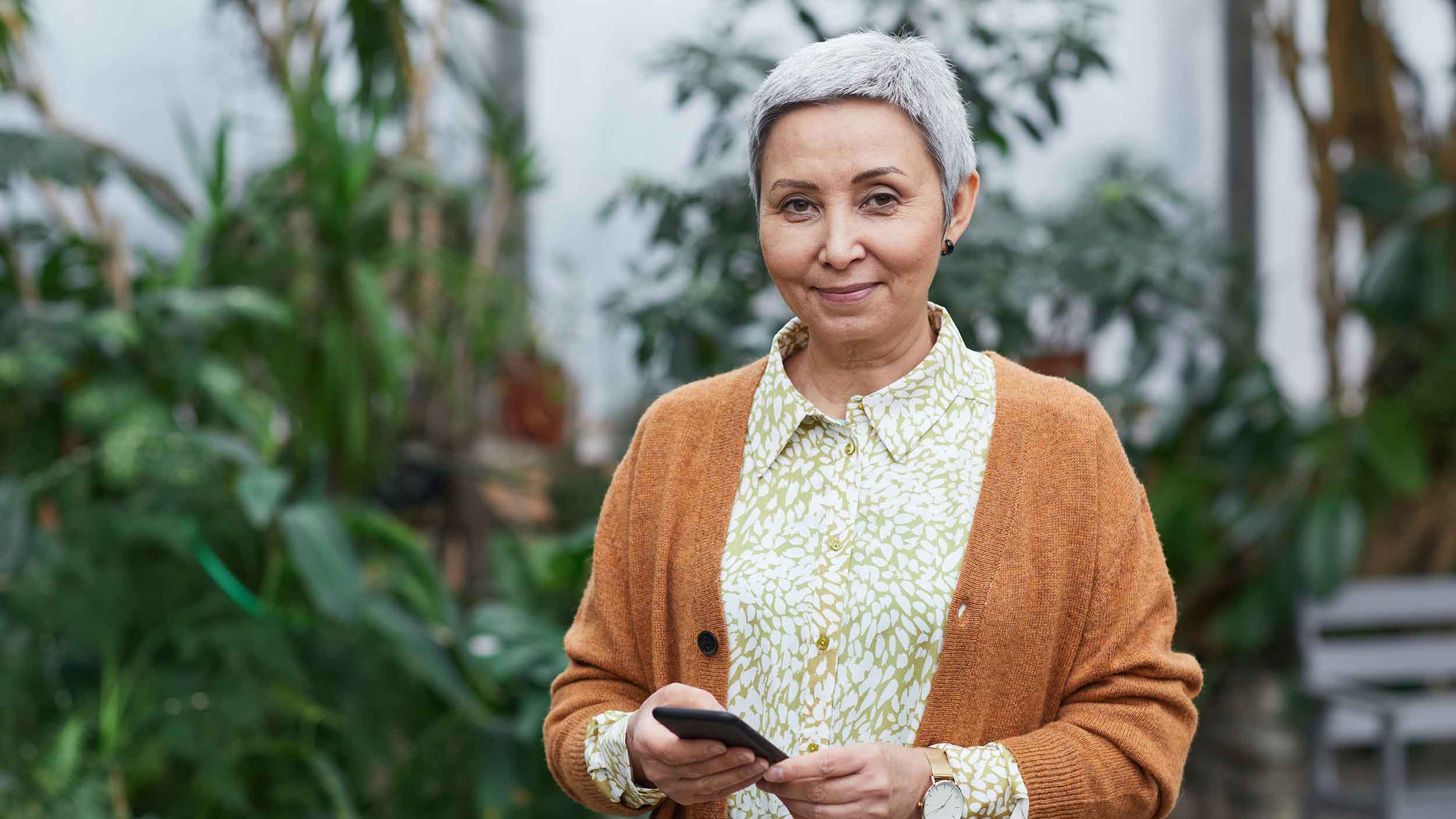 Older woman in cardigan standing outside